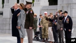 World War II veterans salute as Taps is played during a ceremony at the World War II Memorial to commemorate the 75th anniversary of Victory in Europe Day with President Donald Trump and first lady Melania Trump, Friday, May 8, 2020, in Washington. …