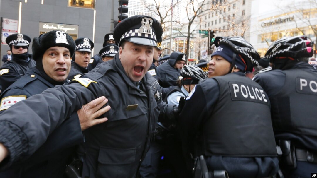 Polisi Chicago saat mengamankan seorang pemrotes di kawasan perbelanjaan "Magnificent Mile" (24/12) lalu. 