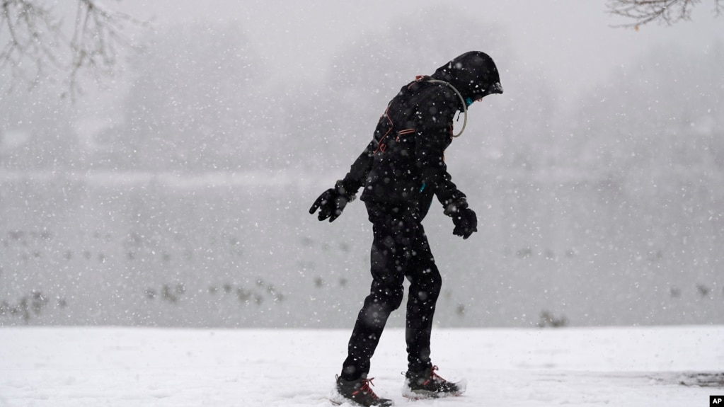 FILE - A lone walker moves around Washington Park as a winter storm packing wet, heavy snow moves through the area on Feb. 3, 2024, in Denver. (AP Photo/David Zalubowski)