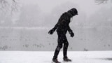 FILE - A lone walker moves around Washington Park as a winter storm packing wet, heavy snow moves through the area on Feb. 3, 2024, in Denver. (AP Photo/David Zalubowski)