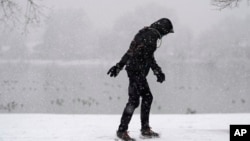 FILE - A lone walker moves around Washington Park as a winter storm packing wet, heavy snow moves through the area on Feb. 3, 2024, in Denver. (AP Photo/David Zalubowski)