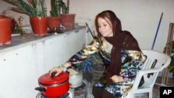 In the garage of her Tripoli house, Fatma Ghobtan checks a pot on a charcoal stove she fashioned from two car wheels after gas was cut off.