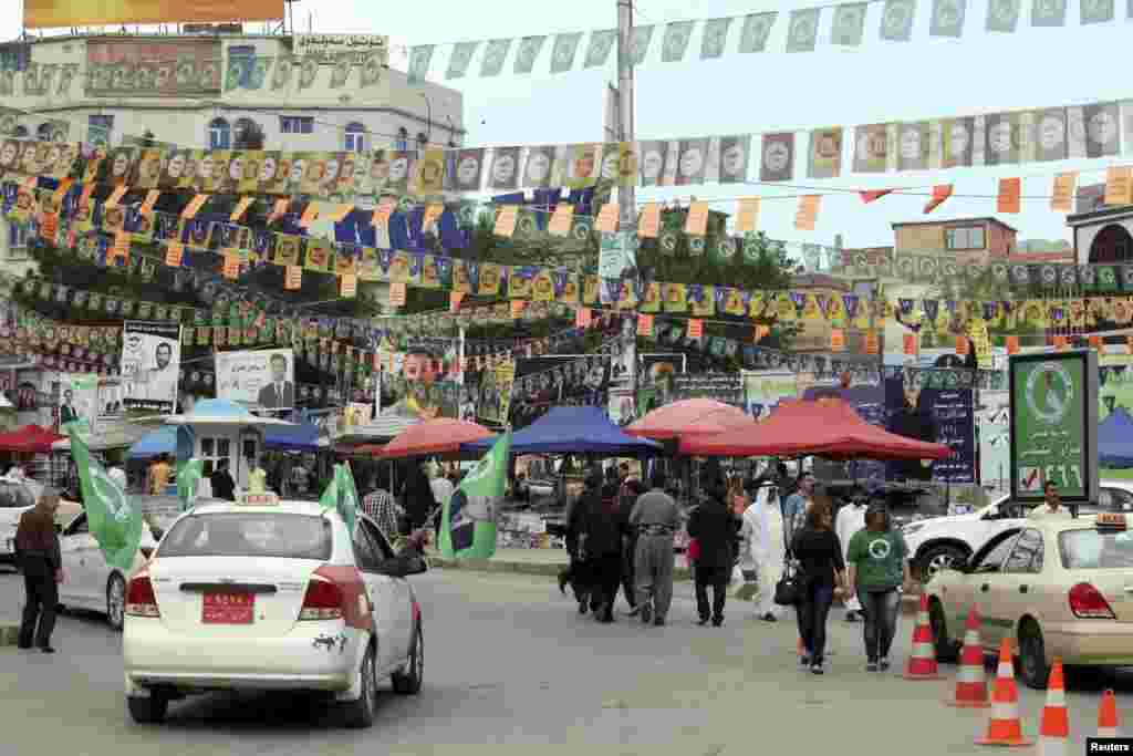 Passengers in a taxi wave PUK (Patriotic Union of Kurdistan) flags, the party of President Jalal Talabani, before the country's parliamentary elections, Sulaimaniya, April 28, 2014.