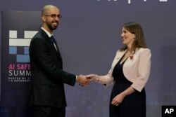 FILE - Britain's Michelle Donelan, Secretary of State for Science, Innovation and Technology, shakes hands with Omar Olama, Minister of State for Artificial Intelligence of the UAE, prior to the AI Saftey Summit in Bletchley Park, Milton Keynes, England, Nov. 1, 2023.