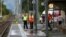 A Swiss police officer stands near workers cleaning a platform after a 27-year-old Swiss man's attack on a Swiss train at the railway station in the town of Salez, Switzerland, Aug. 13, 2016. 