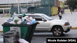 Un hombre revisa un contenedor de basura en el centro de Caracas.