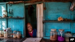 FILE - Phoeswa, a South African traditional medicine pharmacist, waits for customers in the densely populated Alexandra township of Johannesburg, Monday April 6, 2020.