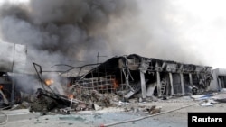 A firefighter works to extinguish a fire at a local market, which was recently damaged by shelling, Donetsk, Ukraine, June 3, 2015.