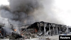 2015年6月3日救火人员在乌克兰顿涅茨克奋力扑救被炮击后的大火。