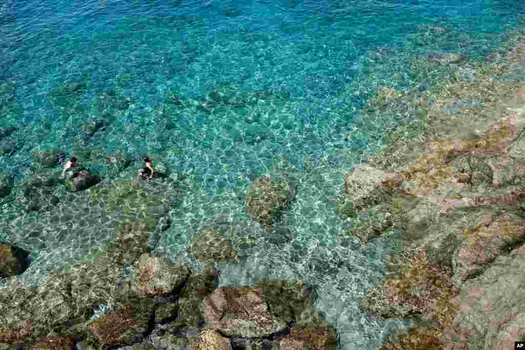با بازشدن سواحل در ایتالیا، این گردشگران از آب زیبا و شفاف در ساحل بوناسولا لذت می‌برند. 