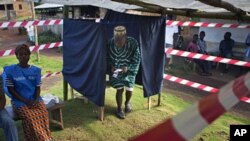 A Liberian man exits a polling booth for the presidential election run-off at Klay town just outside the capital Monrovia, November 8, 2011