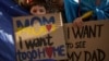 FILE - Ukrainian refugee children hold banners during a protest outside the Russian embassy in Bucharest, Romania, on Oct. 14, 2023.