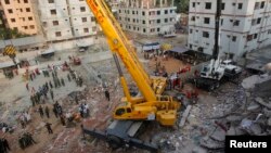 Army soldiers clear up the rubble of the collapsed Rana Plaza building with a crane in Savar, 30 km (19 miles) outside Dhaka, Apr. 28, 2013.