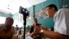 FILE - Journalist and rights activist Le Van Dung (R) conducts a livestream on Facebook in a coffee shop in Hanoi, Vietnam, May 15, 2018.