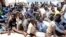 FILE - Illegal migrants sit at a naval base after they were rescued by Libyan coastguard in the coastal city of Tripoli, Libya, May 6, 2017. 