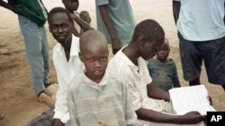 FILE - Sudanese boys pass the time in the Kakuma camp, in northern Kenya, April 24, 2000. Over 20,000 boys who were displaced or orphaned during two decades of civil war endured many hardships as they traveled on foot to refugee camps in Ethiopia and Kenya.