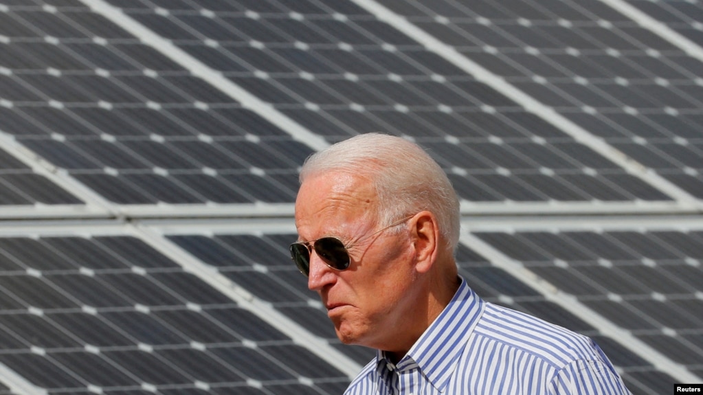 （资料照） 2020年美国民主党总统候选人拜登在普利茅斯走过一片太阳能板。(photo:VOA)