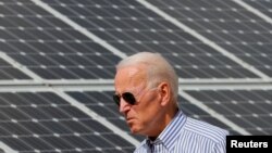 2020年美國民主黨總統候選人拜登在普利茅斯走過一片太陽能板。
