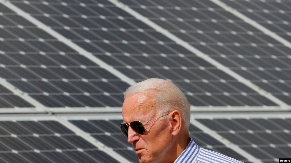 资料图片：民主党 2020 年美国总统候选人拜登走过位于普利茅斯市的太阳能电池板(photo:VOA)
