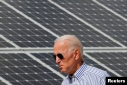 资料照片：美国时任总统候选人和前副总统拜登在新罕布什尔州视察太阳能制造产业。（2019年6月4日）