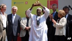 Malick Sidibe montre le Lion d'Or, récompense internationale reçu lors des 52e Biennale de Venise le 11 juin 2007. 