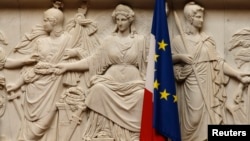 FILE - A French flag is seen alongside a European Union flag at the National Assembly in Paris, France, June 28, 2016.