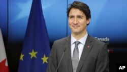 FILE - Canadian Prime Minister Justin Trudeau prepares to address a media conference at the end of an EU-Canada summit at the European Council building in Brussels.