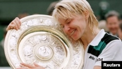 Jana Novotna memeluk Piala Wimbledon setelah mengalahkan Nathalie Tauziat dari Perancis di final Tunggal Putri Wimbledon, 4 Juli 1998. (Foto:Dok)