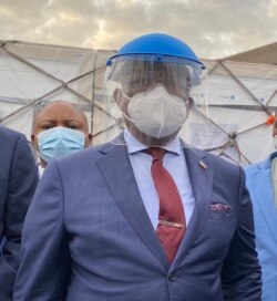 Zimbabwe's Vice President Constantino Chiwenga, who doubles as the country’s health minister, talks to reporters at Robert Mugabe International Airport in Harare, Feb. 15, 2021. (Columbus Mavhunga/VOA)