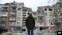 Un residente local mira su casa, dañada por un ataque con cohetes rusos en Sloviansk, región de Donetsk, Ucrania, el viernes 14 de abril de 2023.