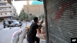 ​ສະມາຊິກກຸ່ມກະບົດຜູ້ນຶ່ງ ກໍາລັງຕັ້ງທ່າຈະຍິງຍົນເຮບີຄອບເຕີ ຂອງ​ທະຫານ​ລັດຖະບານກໍາລັງ ບິນເຫວີ່ນຢູ່ເທິງເມືອງ Aleppo ທາງພາກເໜືອຂອງຊີເຣຍໃນວັນທີ 23 ກໍລະກົດ, 2012.