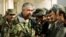 FILE - Rashid Dostum shakes hands with local residents in Shebergan, Afghanistan,, Dec. 27 , 2001. 