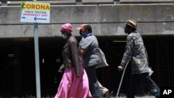 지난 12월 신종 코로나바이러스 감염 검사가 실시되고 있는 남아공 케이프타운의 그루트 슈르 병원 앞을 마스크를 쓴 시민들이 지나가고 있다. 