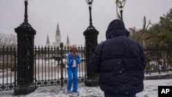 Gumbo Carlin, frente a la costa de Nueva Orleans, toma una fotografía de su esposa Tezrah Carlin frente a Jackson Square durante una tormenta de nieve muy poco común en Nueva Orleans, el 21 de enero de 2025.