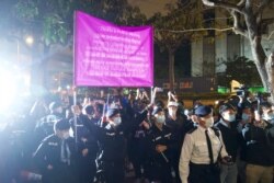 Agentes de policía levantan una bandera de advertencia contra los simpatizantes frente a un tribunal en Hong Kong, el jueves 4 de marzo de 2021.