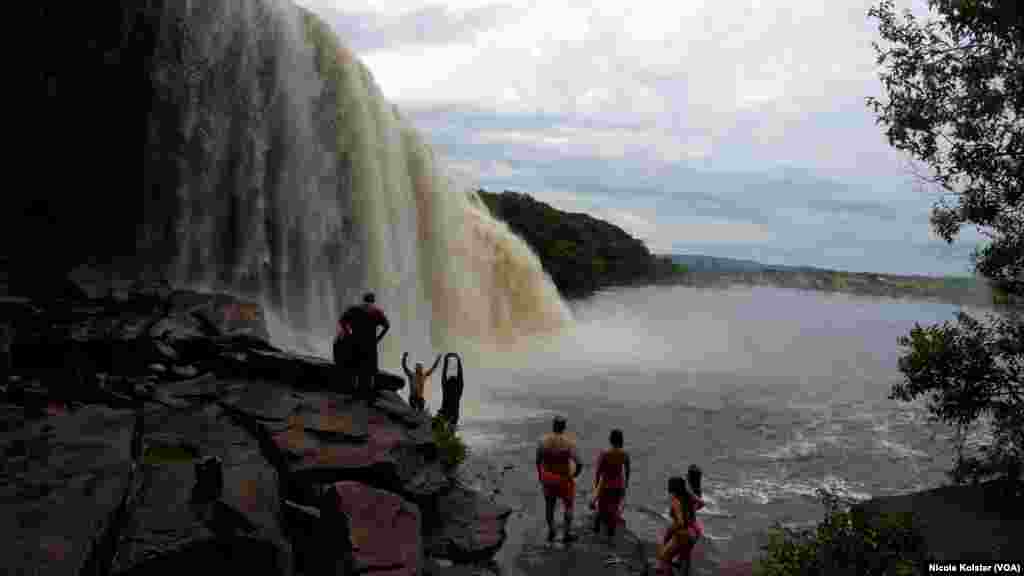 Turistas disfrutan de una cueva detrás de la cascada El Sapo en el Parque Nacional Canaima, Venezuela, el jueves 20 de febrero.