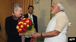 Prime ministerial candidate Narendra Modi (R) presents a bouquet of flowers to US Ambassador to India Nancy Powell Feb. 13, 2014.