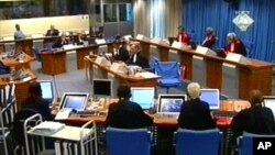 FILE - In this Tuesday Sept. 7, 2004, image made from TV, Slobodan Milosevic, second from top left, appears before the International Criminal Tribunal for the former Yugoslavia in The Hague, Netherlands.