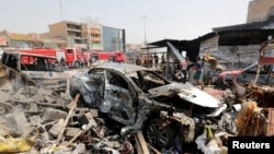 A destroyed car is seen at the site of a car bomb attack in Jamila market in Sadr City district of Baghdad, Iraq, Aug. 28, 2017. 