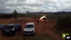 In this still made from an undated video provided by 66.ru, an explosion is seen after a helicopter fired a rocket in Luzhsky range, St. Petersburg region, Russia. A Russian military helicopter gunship accidentally fired on spectators during war games in western Russia, injuring several people, news reports said Sept. 19, 2017.