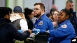 FILE - Transportation Security Administration officers work at a checkpoint at Logan International Airport in Boston, Massachusetts, Jan. 5, 2019. 