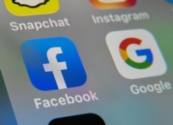 FILE - Logos of mobile apps Facebook and Google displayed on a tablet, Oct. 1, 2019.