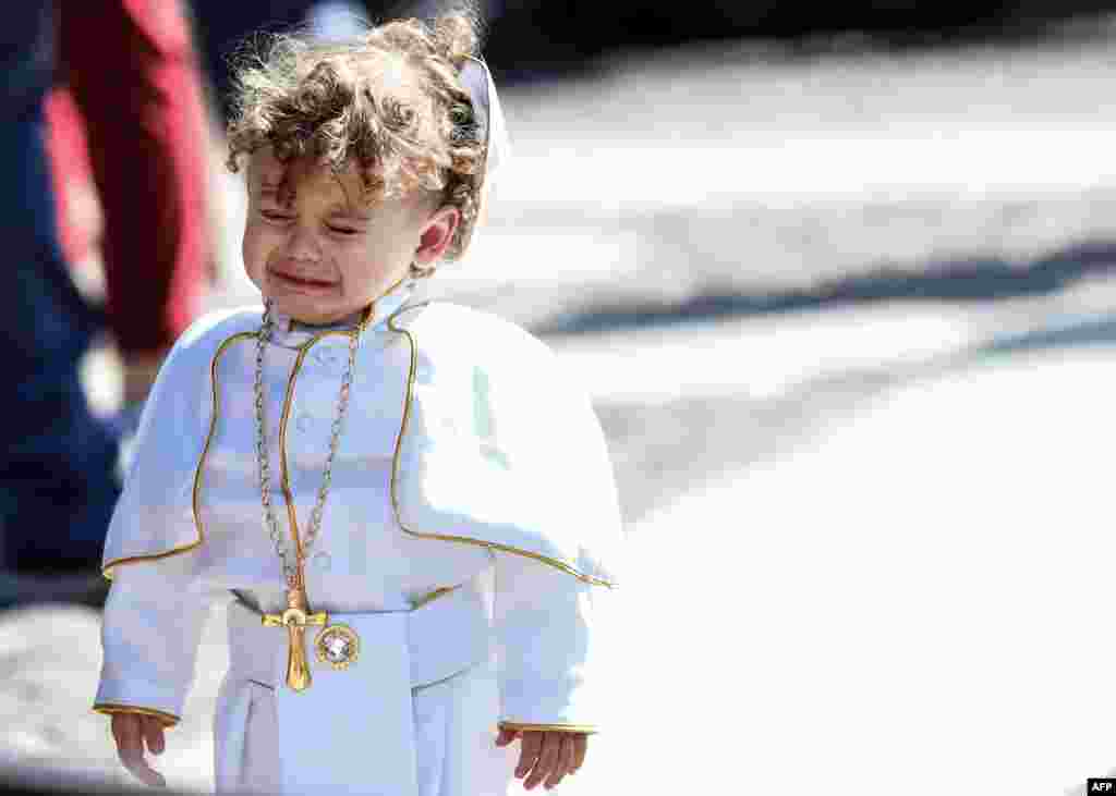 A child dressed as a Pope cries during the weekly Angelus prayer at St. Peter&#39;s square in the Vatican.