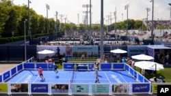 Tennis fans play a version of tennis resembling pickleball on the grounds of the Billie Jean King National Tennis Center during the first round of the U.S. Open tennis championships, Aug. 26, 2024, in New York.