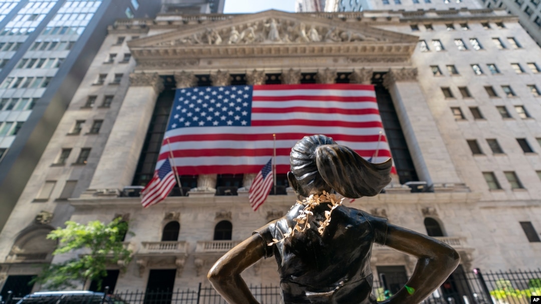 FILE - The "Fearless Girl" bronze sculpture looks toward the New York Stock Exchange, Sept. 21, 2020. 