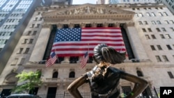 FILE - The "Fearless Girl" bronze sculpture looks toward the New York Stock Exchange, Sept. 21, 2020. 