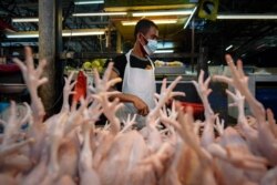 A poultry vendor wearing a face mask to help curb the spread of the coronavirus prepares birds at a wet market in downtown Kuala Lumpur, Malaysia, April 24, 2020.