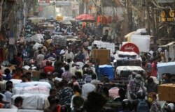 People walk at a crowded market amidst the spread of the coronavirus disease (COVID-19), in the old quarters of Delhi, India, Apr. 6, 2021.