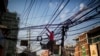 A Bangladeshi man works on the tangled electric cables hanging above a street in Dhaka, Bangladesh, Dec. 12, 2017. 