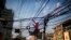 A Bangladeshi man works on the tangled electric cables hanging above a street in Dhaka, Bangladesh, Dec. 12, 2017. 